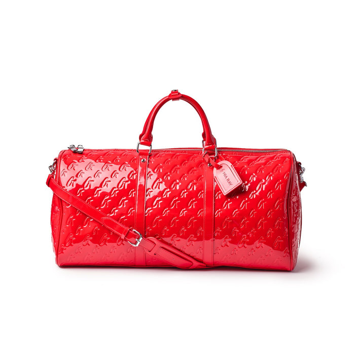 Red Monogram Duffle Bag with embossed logo pattern, top handles, adjustable shoulder strap, and zip closure.