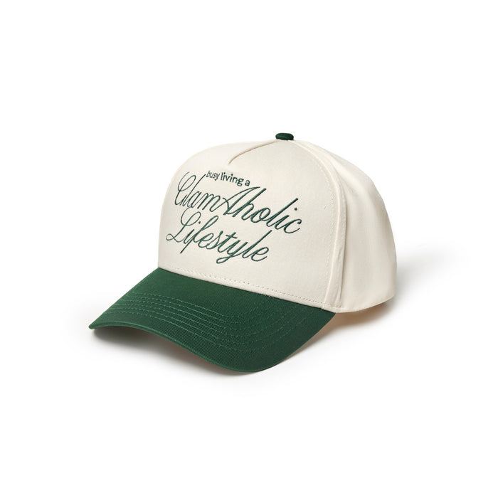 Green trucker hat featuring "Just Living a Glam-Aholic Lifestyle" embroidered on the front.