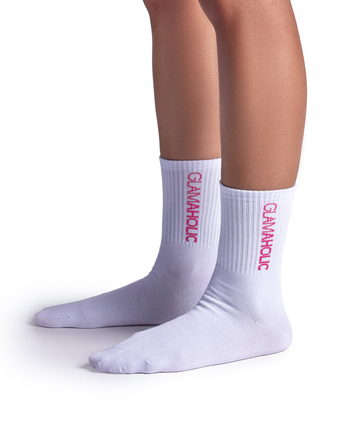 White athletic crew socks featuring a ribbed design and "Glam-Aholic" logo in pink, ideal for sports and casual wear.