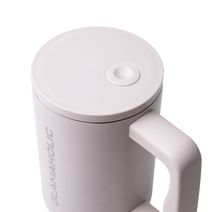 Nude athletic tumbler with a sleek design and a secure lid, featuring a comfortable handle for easy grip.