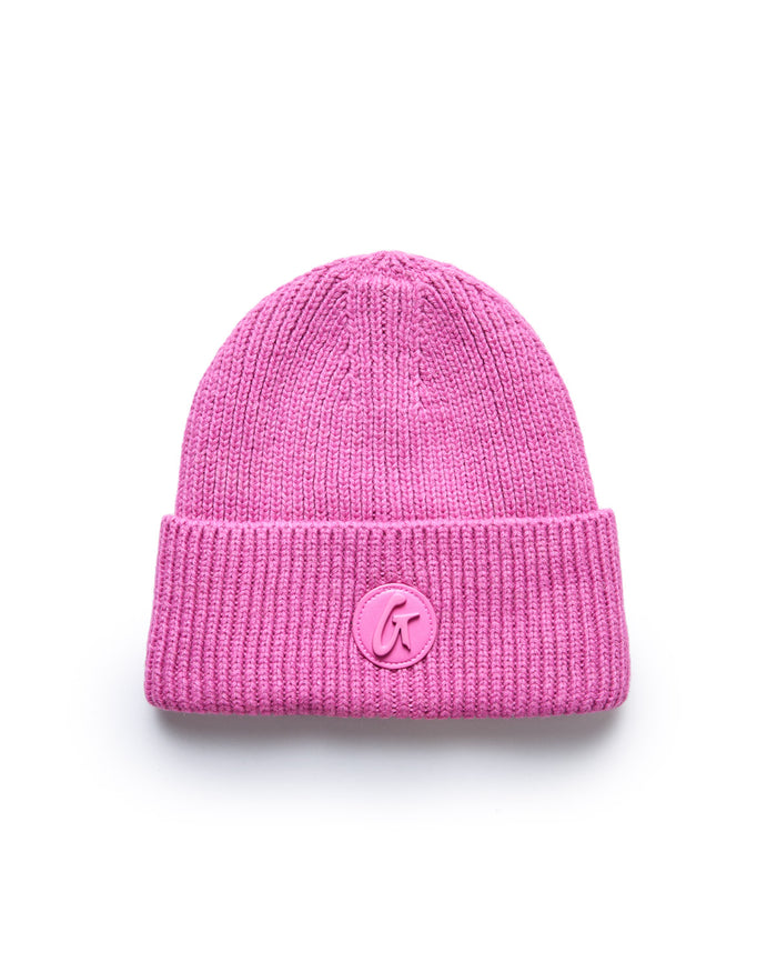 Pink knit beanie with a folded cuff and a circular logo patch featuring a stylized "G" on the front.