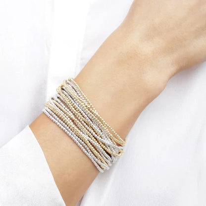 wrist wearing stack of beaded bracelets against a white background