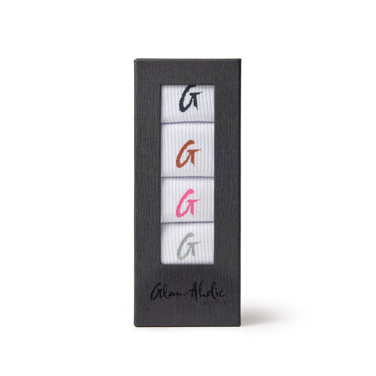 Set of four crew socks in white with colorful embroidered "G" logos in black, orange, pink, and gray, packaged in a black box.