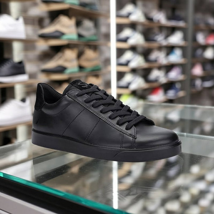 Black leather low-top sneakers with lace-up front and low rubber sole on display.