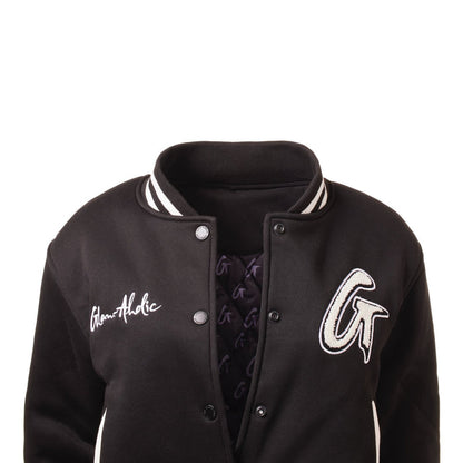 Black varsity jacket with embroidered "GlamAholic" and "G" patches, ribbed collar, and snap button closure.
