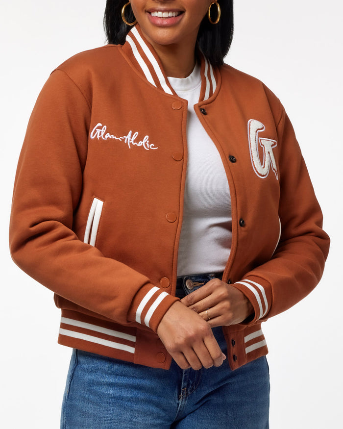 Brown varsity jacket featuring a stylish logo and striped details, perfect for a trendy, casual look.