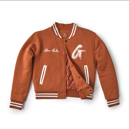 Brown varsity jacket with striped cuffs, collar, and waistband, featuring embroidered patches and side pockets.