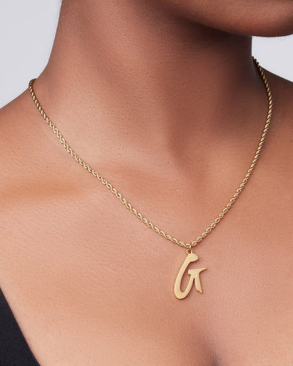 Gold necklace featuring a delicate twisted chain and a stylish initial pendant, perfect for adding elegance to any outfit.