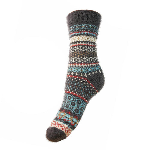 A pair of grey, blue, and white Nordic patterned wool socks.