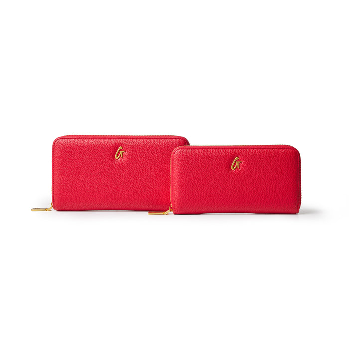 Red jumbo pebble leather wallets with gold logo accents, one larger and one smaller, on a white background.