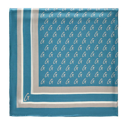 Large blue and silver silk scarf with a monogram pattern featuring white "G" logos and a bordered design.