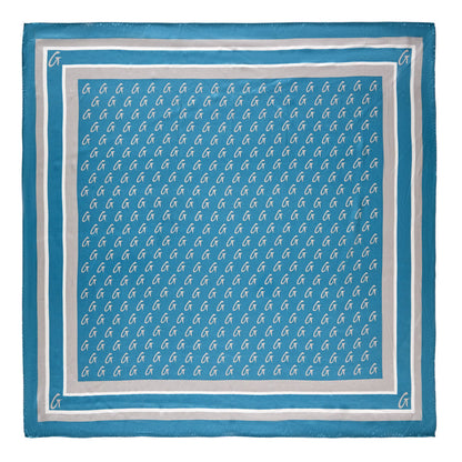 Large blue silk scarf with silver monogram pattern, featuring repeated "G" initials and border accents.