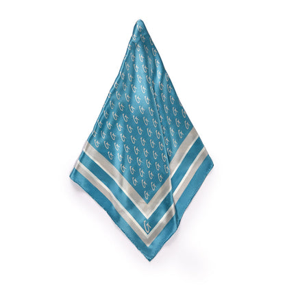 Large blue silk scarf with silver monogram pattern, border design, and a small logo in the corner.