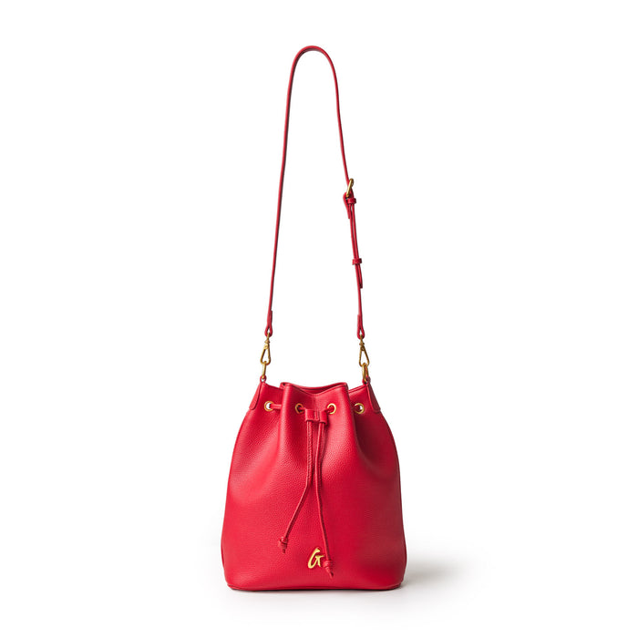 Red pebble bucket bag with gold hardware and adjustable strap, featuring a drawstring closure and a small gold logo charm.