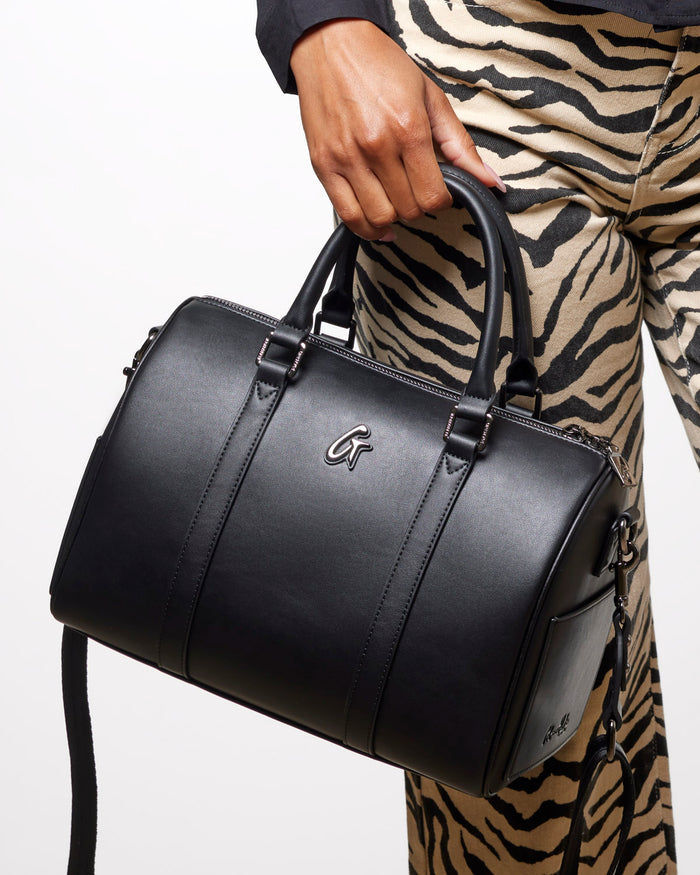 Large black Boston bag with sleek design, featuring dual handles and a detachable strap, perfect for stylish everyday use.