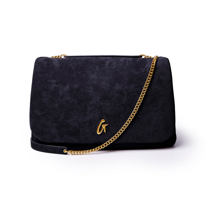 Large black suede flap bag with a gold chain strap and an embossed logo, perfect for stylish, affordable luxury.