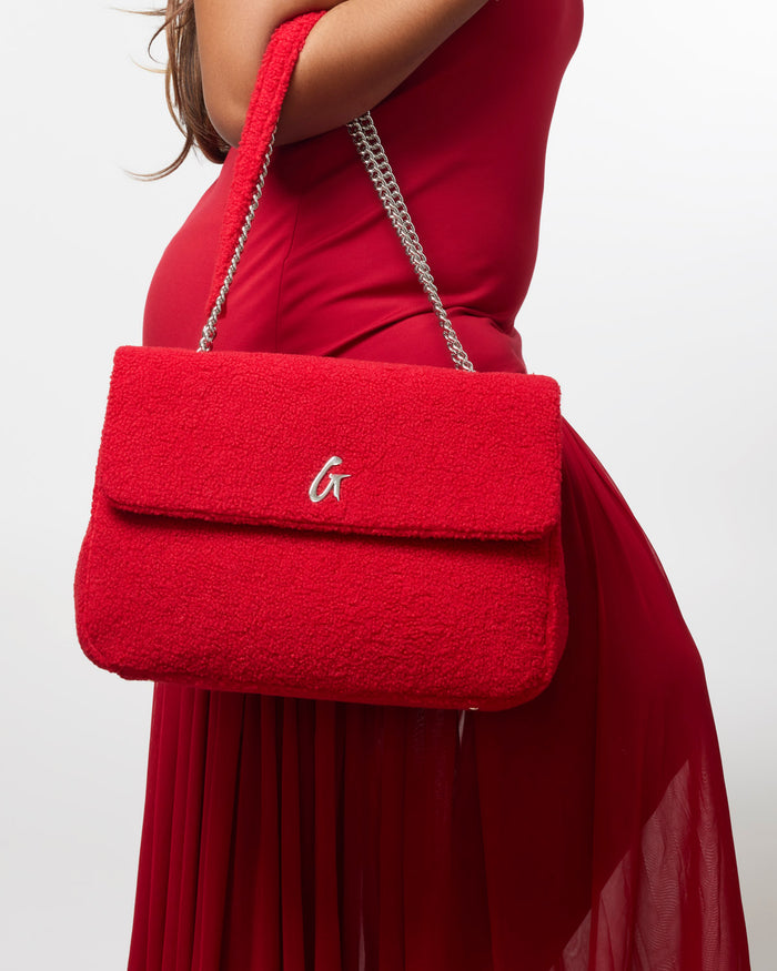 Red large teddy flap bag with a plush texture and silver chain strap, perfect for adding a touch of luxury to any outfit.