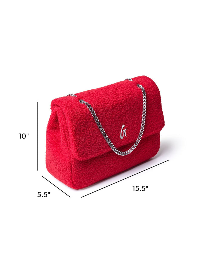 Large red teddy flap bag with a silver chain strap, featuring a stylish logo and plush texture.