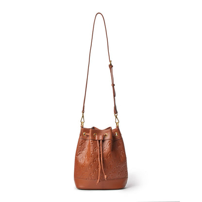 Medium brown bucket bag with monogram pattern, drawstring closure, and adjustable shoulder strap.