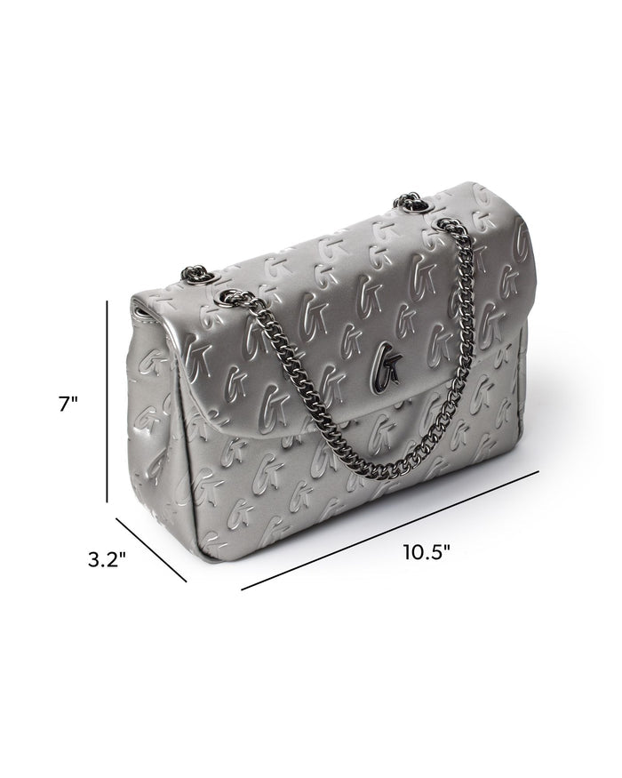 Medium monogram flap bag in platinum with a chain strap, featuring embossed logo design and elegant silhouette.