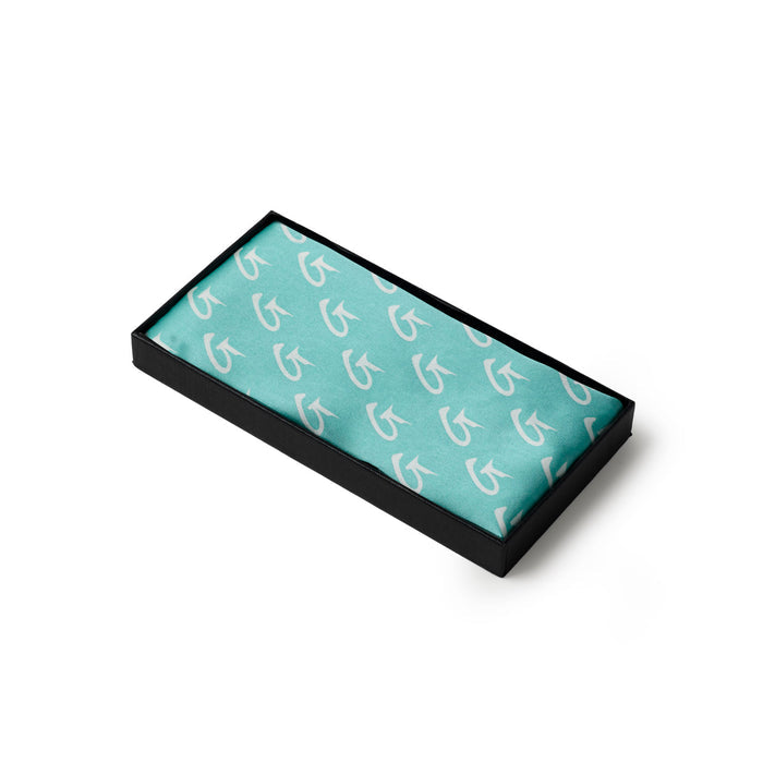 Teal medium monogram silk scarf displayed in a sleek black box, showcasing a stylish pattern for luxury appeal.