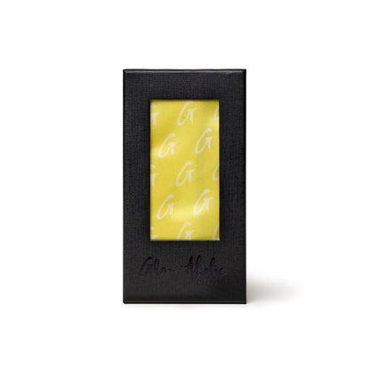 Medium yellow silk scarf featuring a monogram pattern, elegantly packaged in a sleek black box.