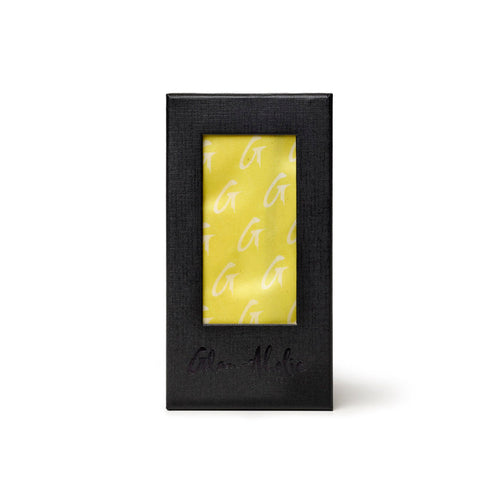 Medium yellow silk scarf featuring a monogram pattern, elegantly packaged in a sleek black box.
