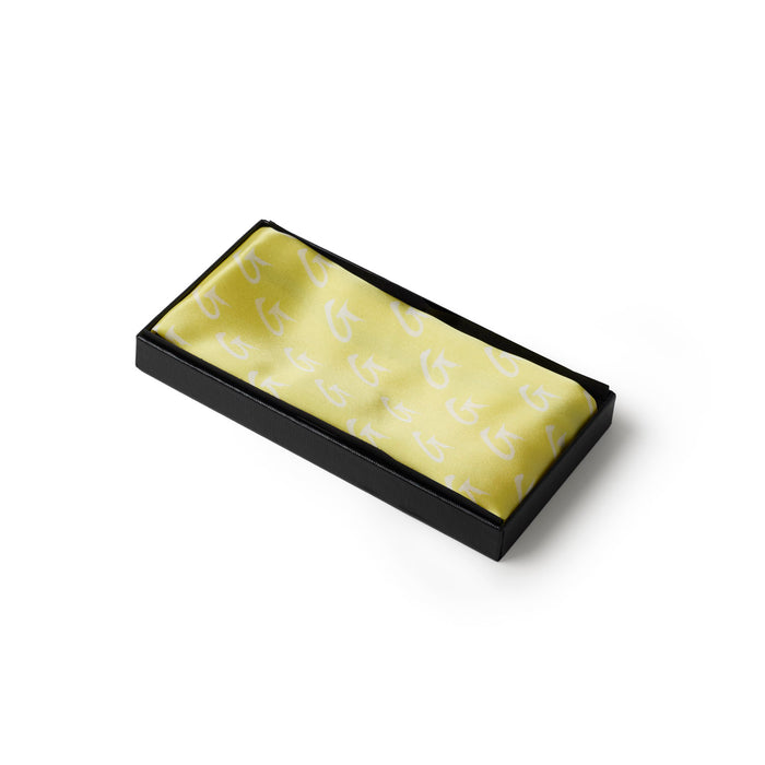 Medium yellow silk scarf featuring a subtle monogram design, elegantly packaged in a sleek black box.