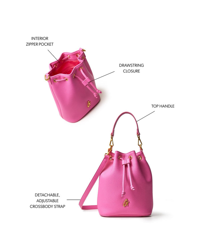 Hot pink medium pebble bucket bag featuring a drawstring closure, top handle, and detachable adjustable crossbody strap.