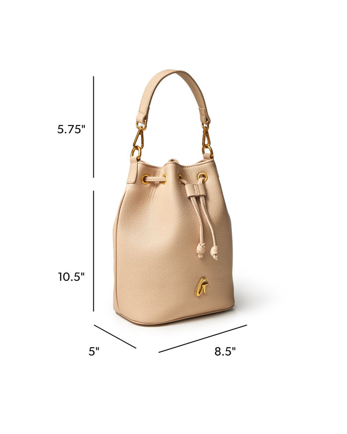Medium pebble bucket bag in nude with gold accents, featuring a drawstring closure and a stylish silhouette.