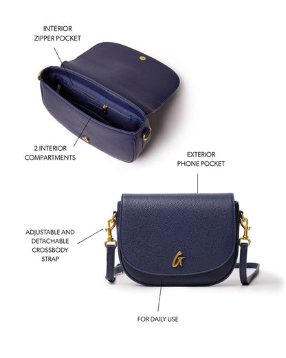 Navy medium pebble shoulder bag with adjustable crossbody strap, exterior phone pocket, and interior compartments.