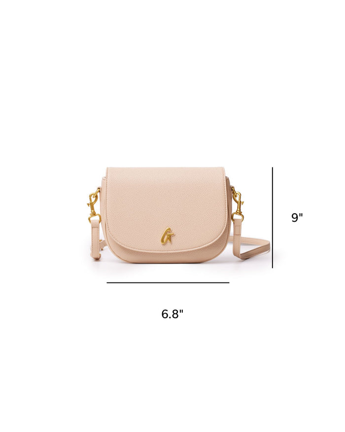 Medium pebble shoulder bag in nude with a sleek design, featuring a gold-tone logo and adjustable strap.