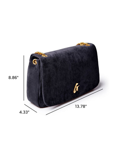 Medium black suede flap bag with gold chain strap, featuring a sleek design and elegant logo detail.