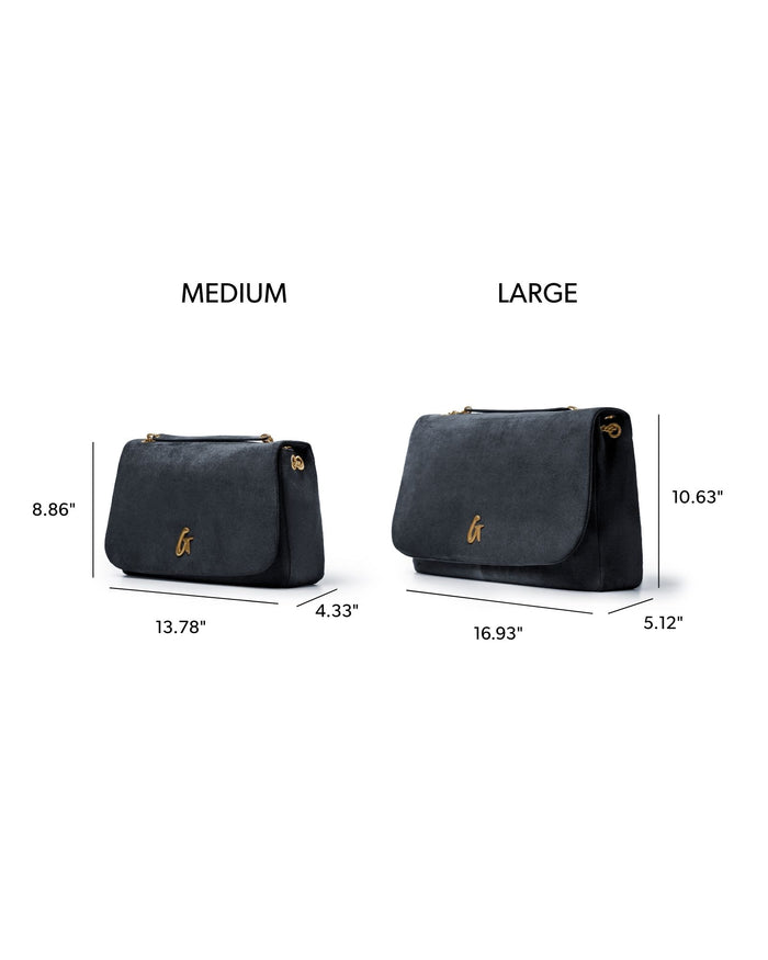Medium black suede flap bag with gold hardware, featuring a sleek design and spacious interior for everyday use.