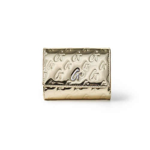 Metallic gold compact wallet with embossed monogram pattern and a central logo detail.