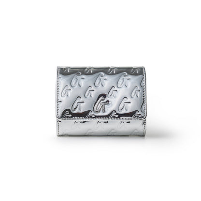 Metallic silver compact wallet with embossed G logo pattern and a flap closure, featuring a sleek, shiny finish.