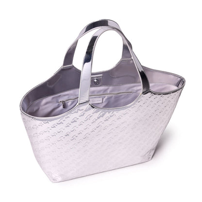 Metallic silver tote bag with embossed monogram pattern, shiny handles, and spacious interior with zip pocket.