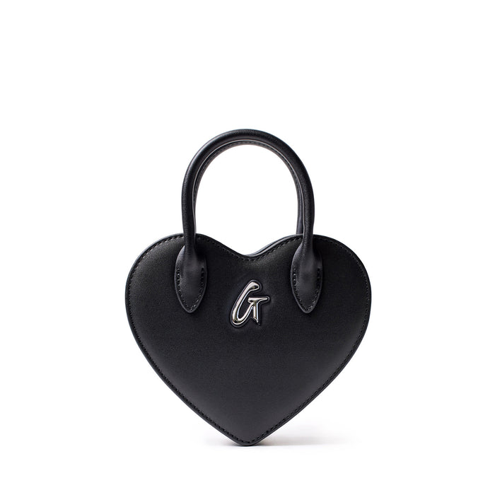 Small black heart-shaped bag with a top handle and silver "G" logo on the front, made of smooth faux leather.