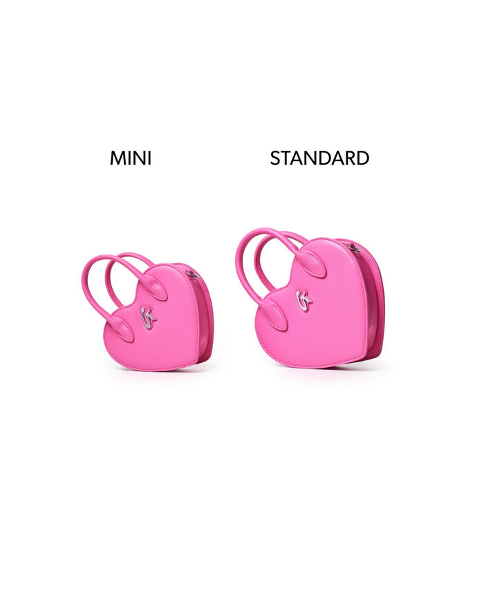 Mini heart-shaped pink handbag displayed alongside a standard size for comparison, showcasing its stylish design.