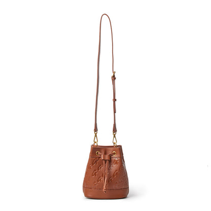 Brown Monogram Bucket Bag with adjustable strap, embossed logo pattern, and gold-tone hardware.