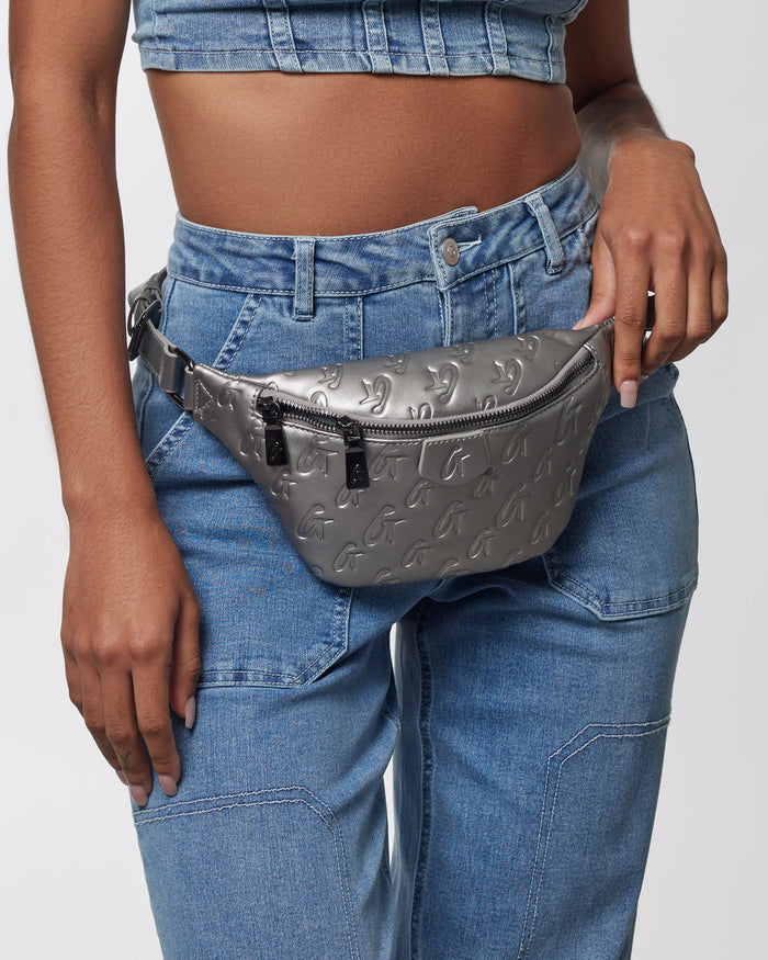 Stylish platinum mini monogram fanny pack worn at the waist, featuring a sleek design and functional zipper.