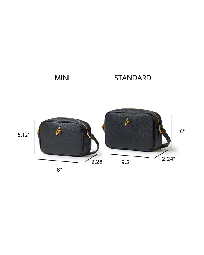 Mini Pebble Camera Bag in black with gold logo, featuring dimensions for mini and standard sizes for comparison.