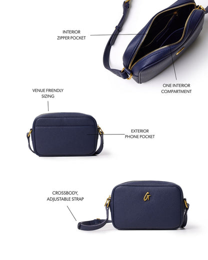 Navy mini pebble camera bag with adjustable crossbody strap, exterior phone pocket, and interior zipper compartment.