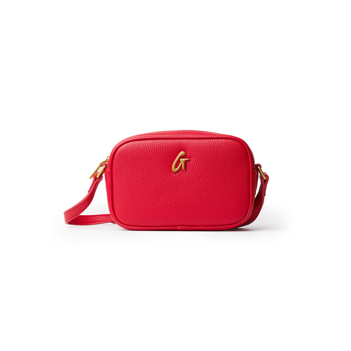 Red mini pebble camera bag with a gold logo and adjustable strap, perfect for carrying small essentials stylishly.