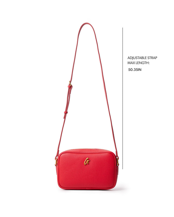 Red mini pebble camera bag with an adjustable strap, perfect for stylish and affordable luxury.