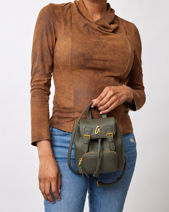 Mini pebble crossbody backpack in olive green, featuring gold hardware and a compact, textured leather design.