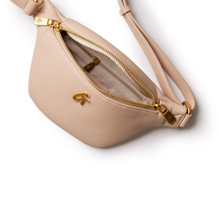 Mini pebble nude fanny pack with gold zipper and logo, featuring a sleek, compact design on a white background.