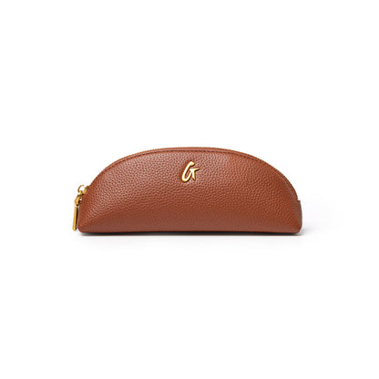 Brown pebble pencil pouch with a sleek design and gold logo, perfect for organizing writing tools and accessories.