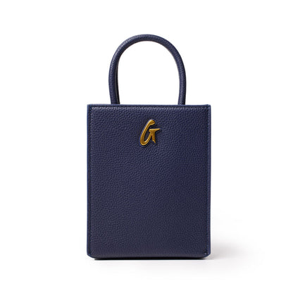 Mini Pebble Tote in navy blue with textured leather, gold-tone logo detail, and top handle, compact and stylish for everyday use.