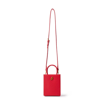Red mini pebble leather tote bag with a top handle, gold logo detail, and adjustable shoulder strap on a white background.